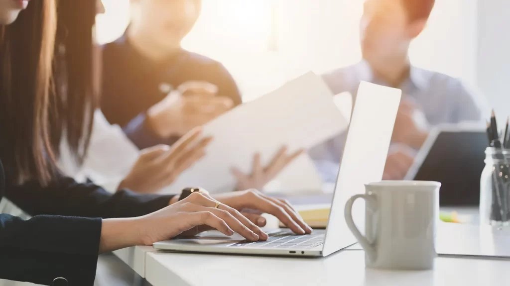 Equipe faz cálculos em papéis e calculadora, ilustrando o planejamento financeiro para a Reforma Tributária 2025.