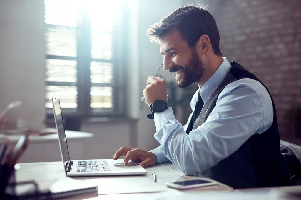 Profissional analisando a DRE no computador — IFRS 18: categorias Operacional, Investimento e Financiamento (CPC 51).