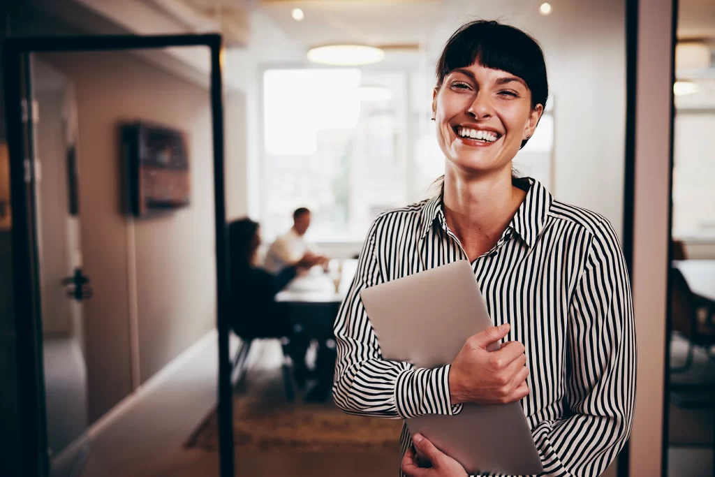 Contadora sorrindo em escritório após cumprir 40 horas de educação continuada CFC 2025