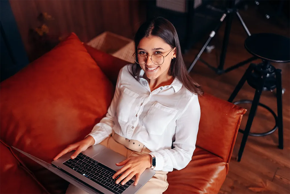 Contadora consultiva sorrindo enquanto trabalha no laptop em ambiente moderno — contabilidade consultiva 2026