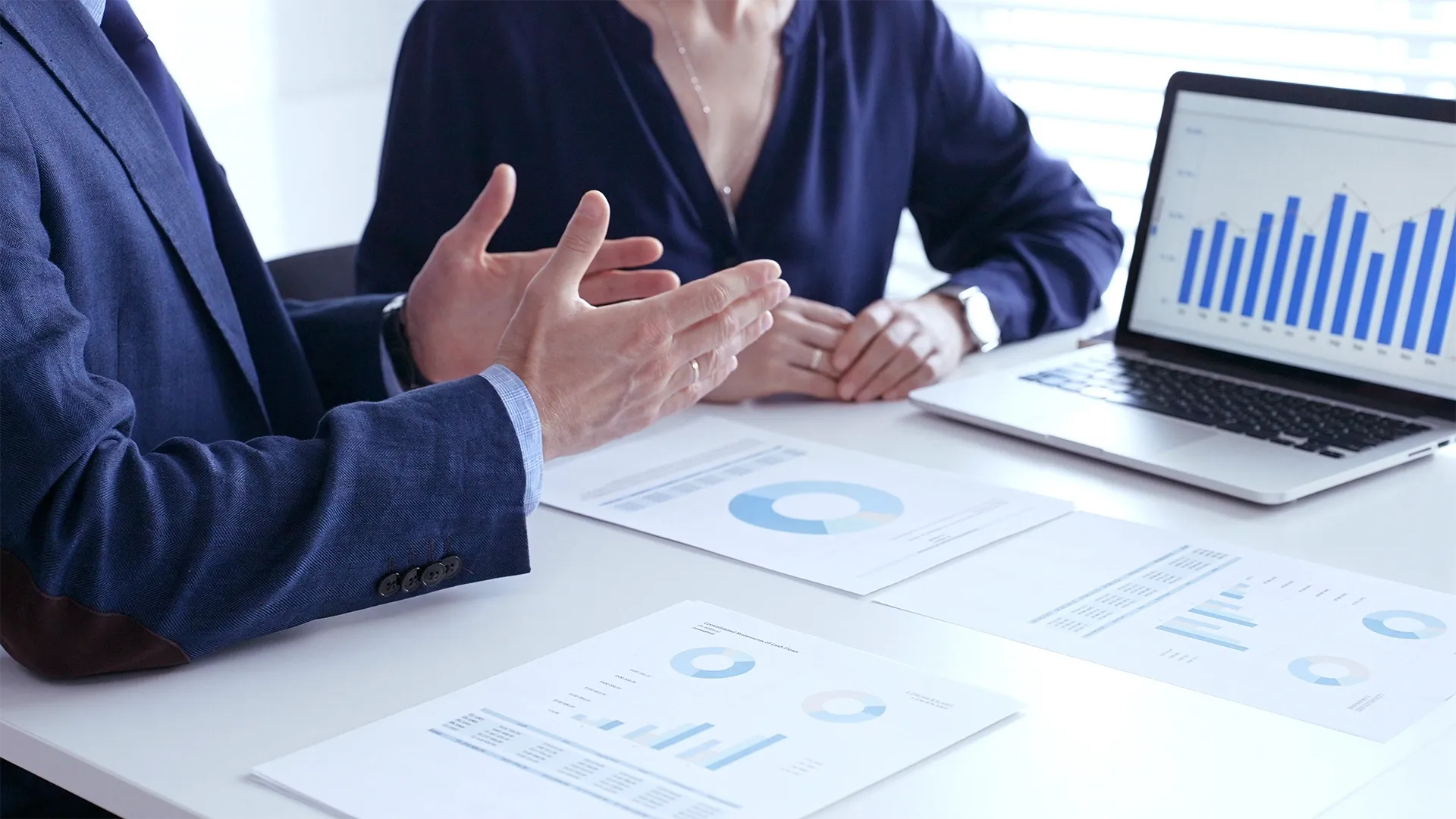 Profissionais analisando gráficos e relatórios financeiros em reunião de planejamento do 1º trimestre