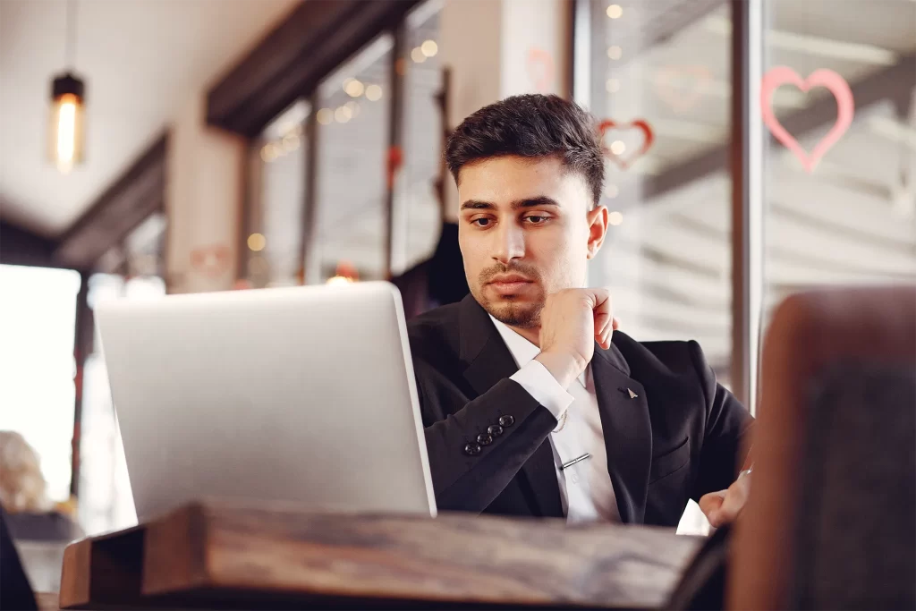 Profissional em ambiente corporativo trabalhando no notebook com análise contábil e financeira para startups