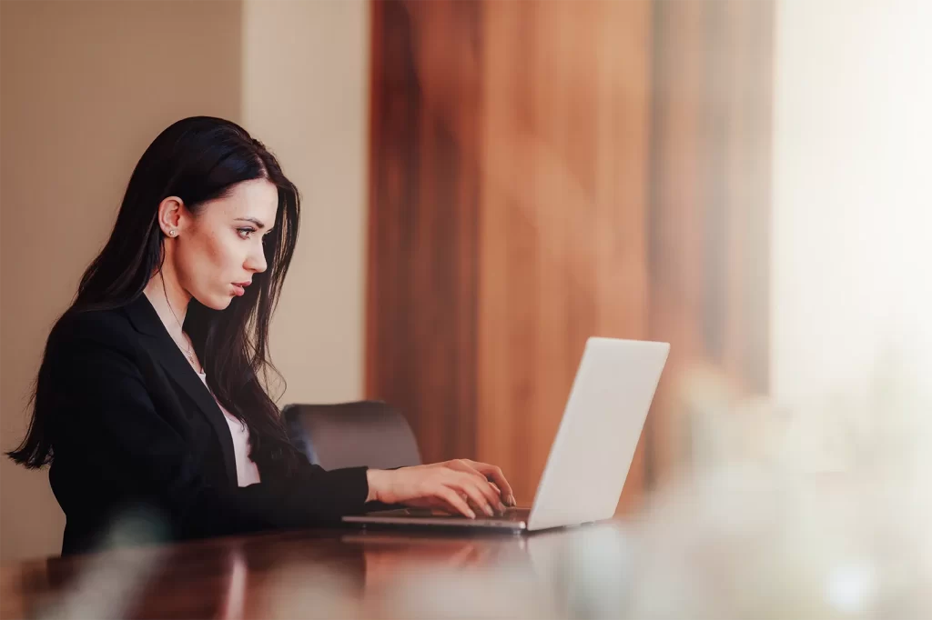 Profissional contábil analisando a ECF 2026 no computador com documentos fiscais do SPED na tela