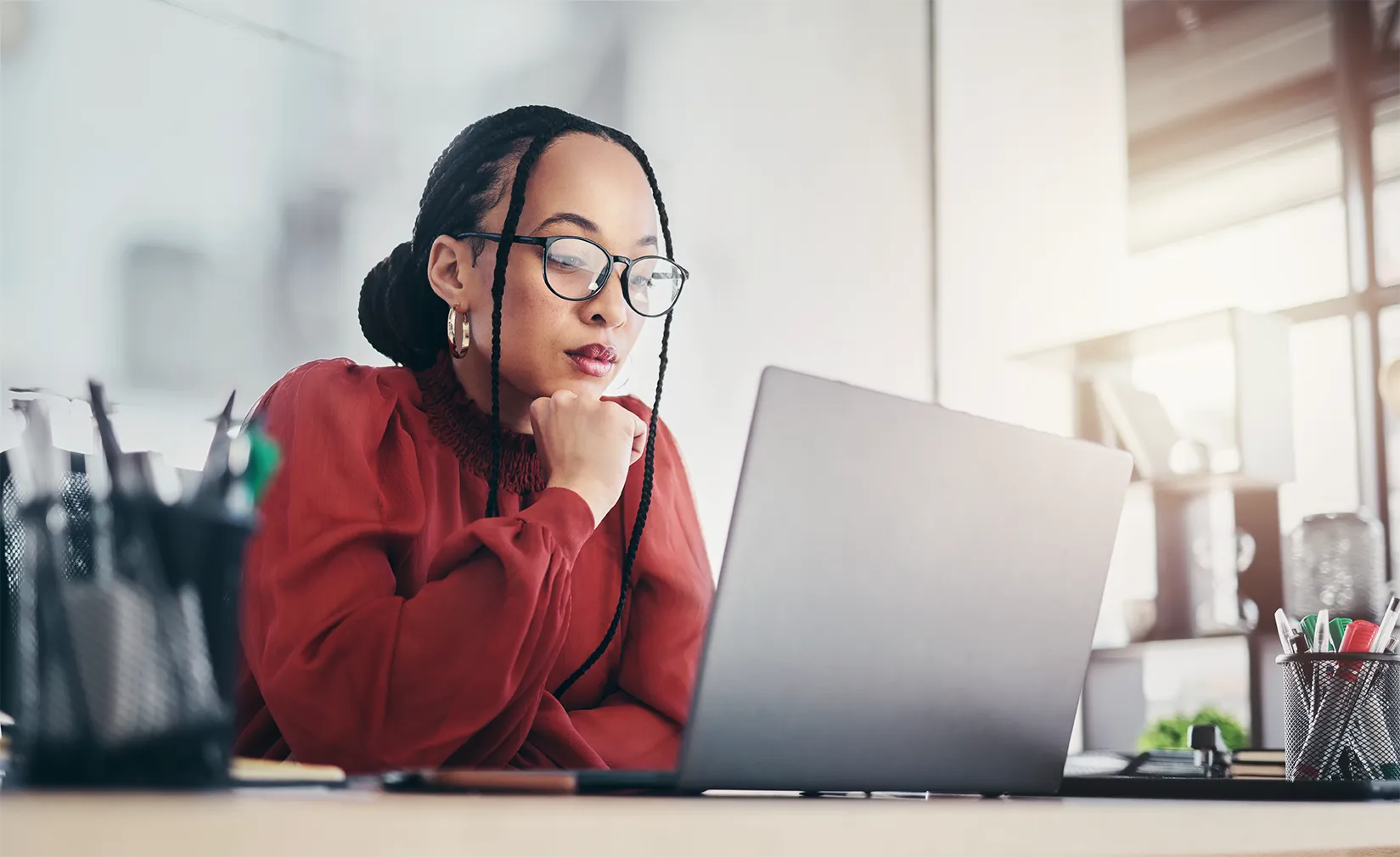 Profissional de Departamento Pessoal analisando no notebook regras e cálculos de férias coletivas para regularização na folha.