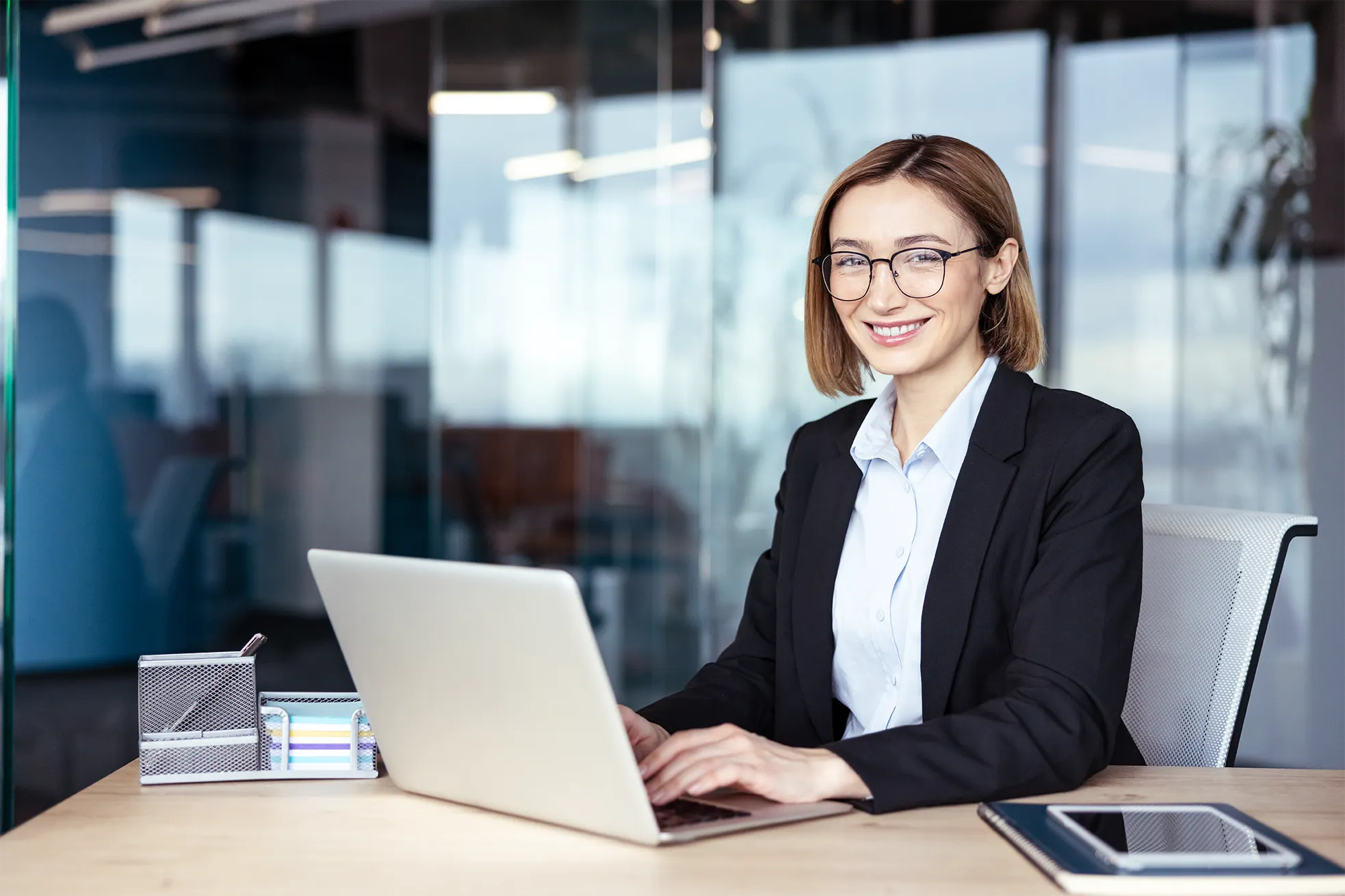 Profissional de contabilidade em escritório usando notebook para atualizar tabelas e valores da folha de pagamento 2026.