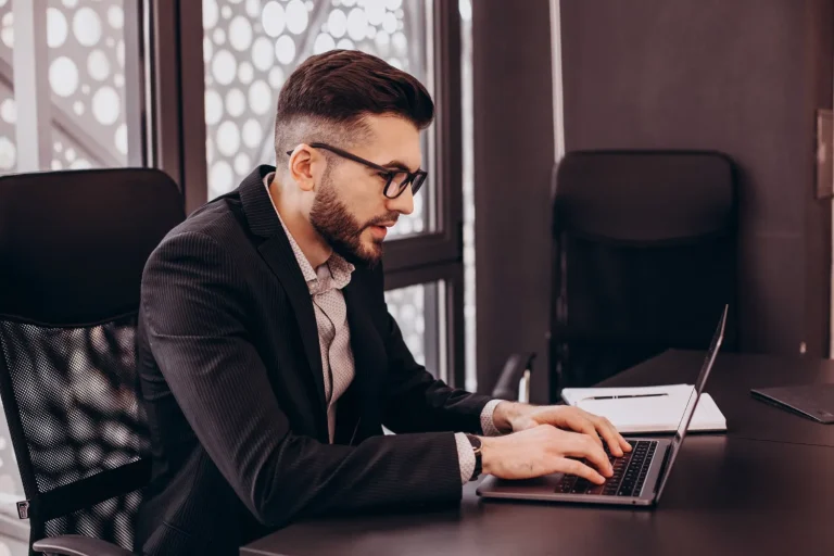 Profissional contábil conferindo no notebook a apuração assistida do IBS e da CBS