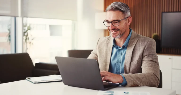 Homem analisando informações no notebook sobre as mudanças de PIS, IPI, ICMS e ISS na Reforma Tributária