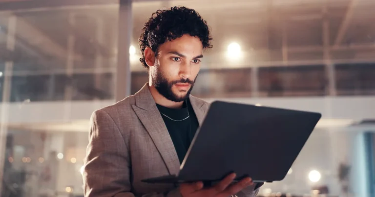 Profissional analisa no notebook o impacto do saneamento na Reforma Tributária para as concessionárias de água e esgoto